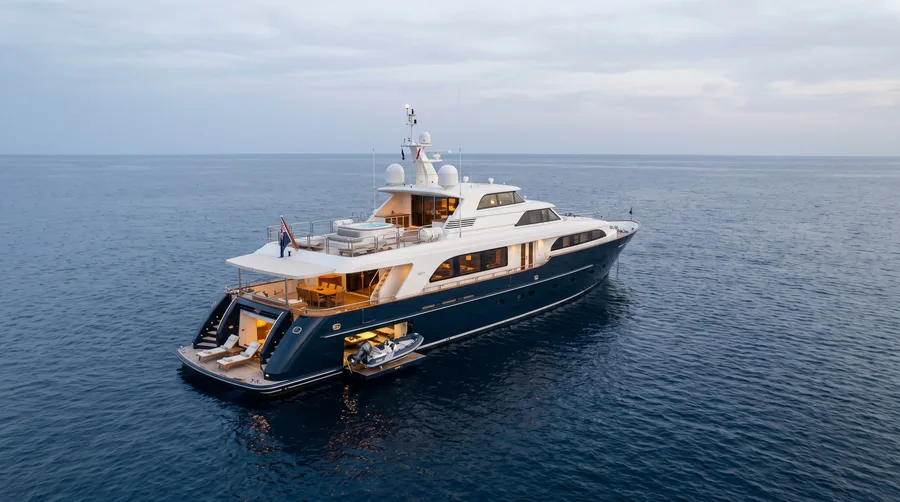 A motor yacht under way in a bay, its decks marked point by point