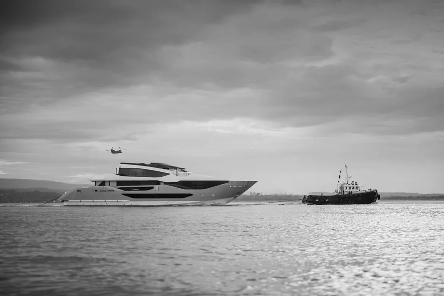 The Sunseeker 134 Superyacht under way off the Dorset coast with a tug and a helicopter
